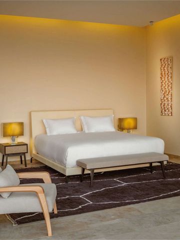 Helles Schlafzimmer mit Kingsize-Bett und stilvollen Lampen