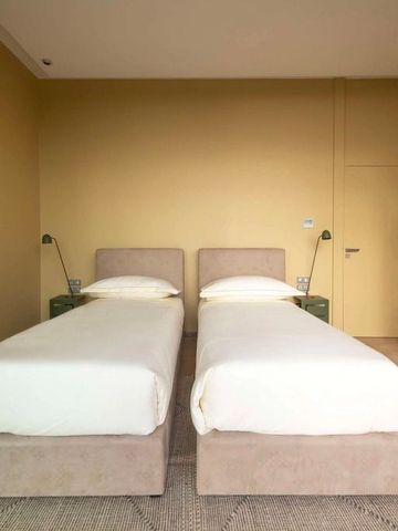 Geräumiges Doppelzimmer mit zwei Einzelbetten und modernen Lampen