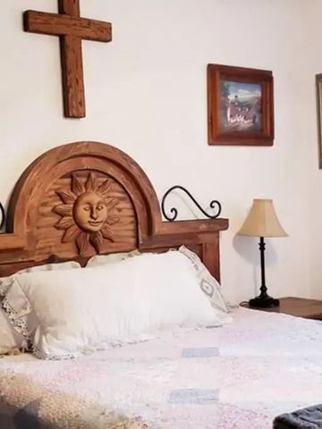 Schlafzimmer mit Holzbett und dekorativen Kunstwerken an der Wand