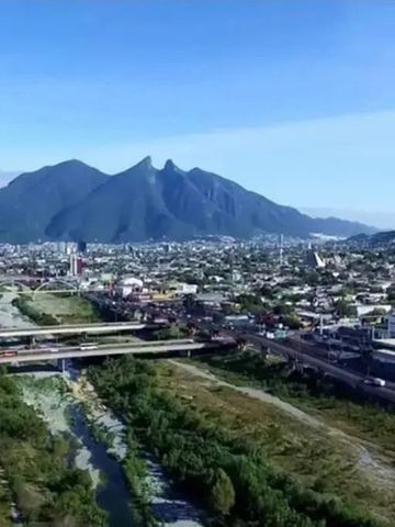 Luftaufnahme einer Stadt mit Fluss und Bergen im Hintergrund