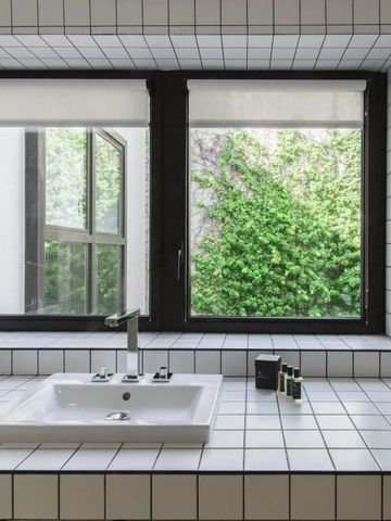 Moderne Badausstattung mit Fliesen und Blick ins Grüne