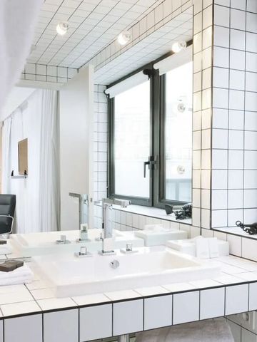 Großzügiges Badezimmer mit weißem Fliesendesign und natürlichem Licht