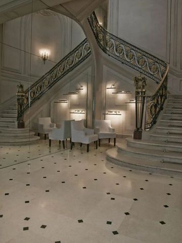 Prächtige Treppe mit verziertem Geländer und edlen Sitzmöbeln