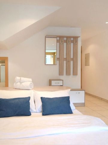 Elegantes Schlafzimmer mit dunklen Kissen und Handtüchern auf dem Bett