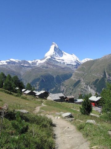 Sommerliche Landschaft mit Matterhorn und alpinen Hütten