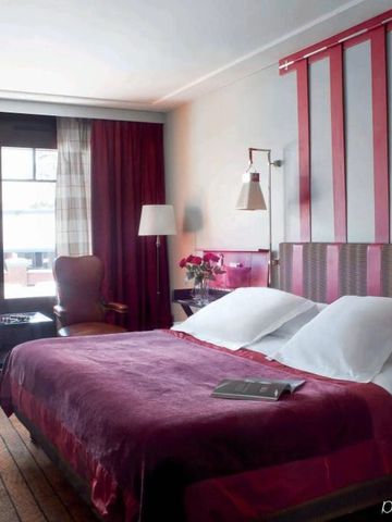 Komfortables Hotelzimmer mit großen Fenstern und rotem Bettüberwurf