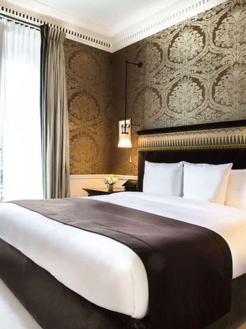 Elegantes Hotelzimmer mit luxuriöser Wandverkleidung und großem Bett im La Reserve Paris