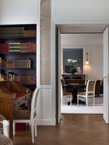 Elegantes Wohnzimmer mit Holzboden und Bücherregal im Hotel in Paris