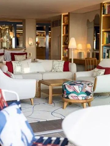 Gemütlicher Lounge-Bereich mit weißen Sofas und bunter Deko.