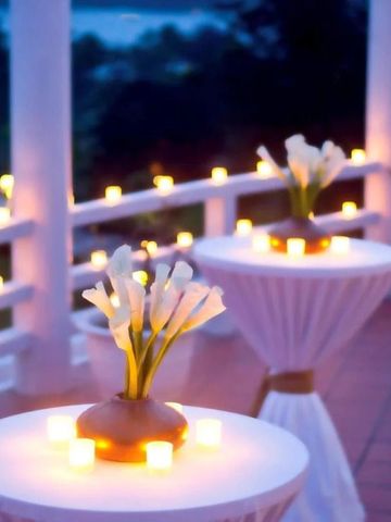 Romantische Terrasse mit Blumen und Kerzen bei Nacht