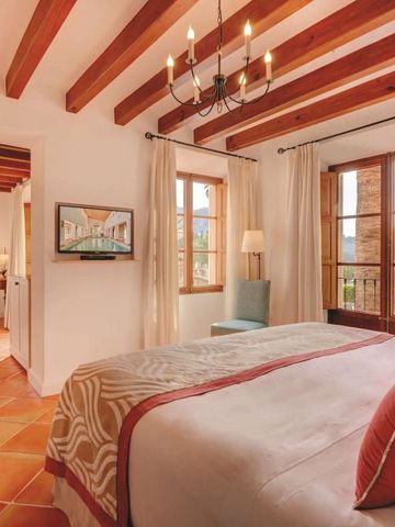 Geräumiges Schlafzimmer mit Holzbalkendecke und Balkonblick