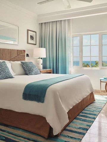 Helles Schlafzimmer mit großem Doppelbett und Meerblick