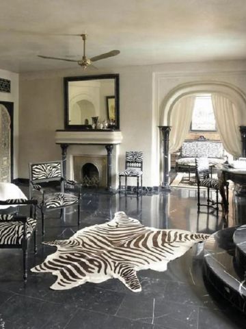 Luxuriöses Wohnzimmer mit Zebramusterteppich und stilvollen Möbeln.