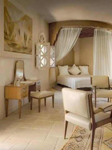 Helles Schlafzimmer mit Baldachinbett und eleganten Möbeln.