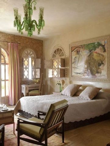 Hotelzimmer mit künstlerischem Dekor und grünem Kronleuchter.