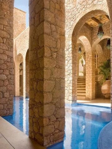 Markante Steinbögen umgeben von einem Poolbereich im Hotel La Sultana Oualidia