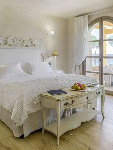 Einladendes Schlafzimmer mit großem Bett und Balkon mit Meerblick