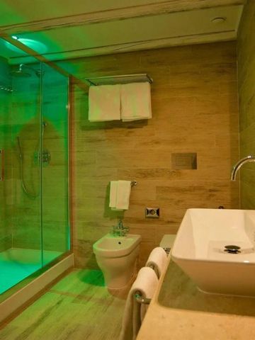 Modernes Badezimmer mit geräumiger Dusche in grünem Licht