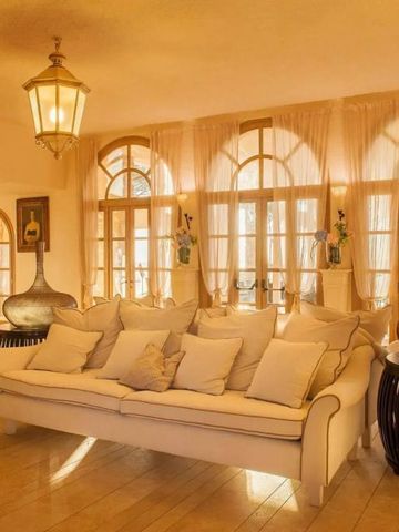 Elegante Lounge mit Sofas und großen Fenstern mit Vorhängen