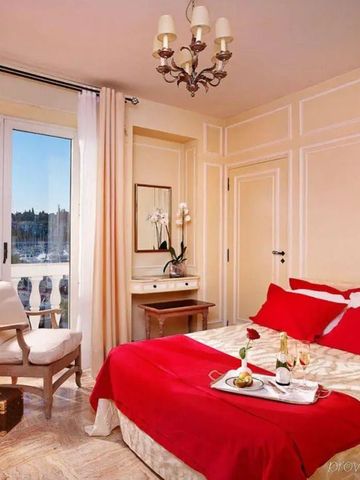 Elegantes Hotelzimmer mit Doppelbett und Balkon mit Meerblick.