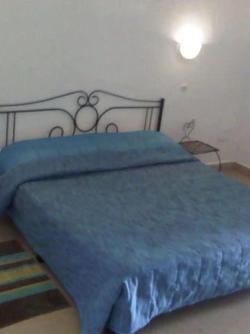 Hotelzimmer mit großem Doppelbett und Wandleuchten