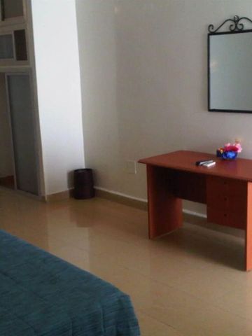 Schlichtes Zimmer mit Schreibtisch, Spiegel und Bett