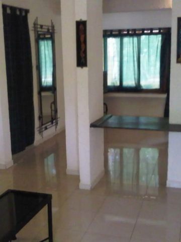 Geräumiger Wohnbereich mit großen Fenstern und hellem Boden