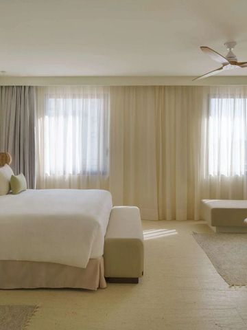 Helles und geräumiges Hotelzimmer mit großen Fenstern und neutralen Farben