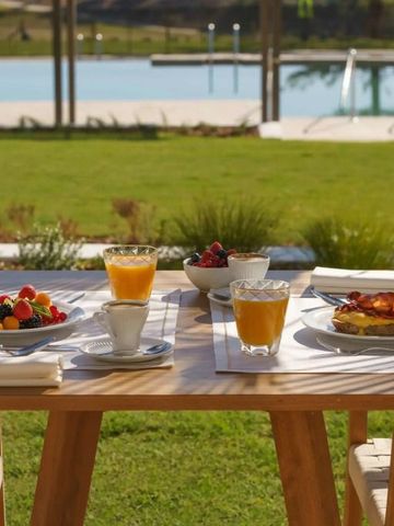 Frühstückstisch im Freien mit Blick auf den Pool und Garten
