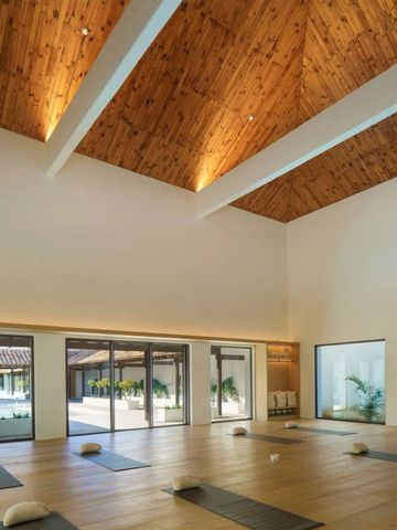 Yogaraum mit Holzbalkendecke und großen Fenstern im Hotel