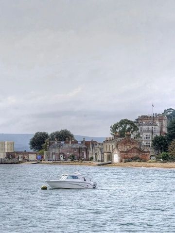 Historisches Gebäude am Seeufer mit bewölktem Himmel
