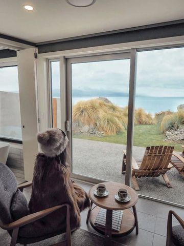 Zimmerblick mit gemütlicher Sitzecke und Terrasse mit Seeblick