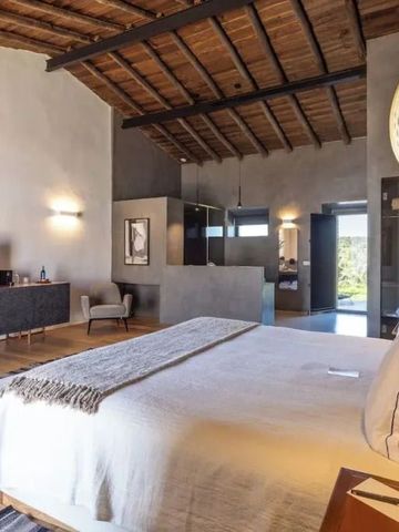 Großes Zimmer mit Holzbalkendecke und gemütlichem Bett