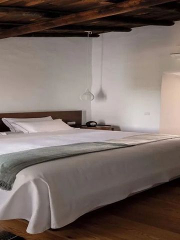 Geräumiges Schlafzimmer mit hellem Interieur und Holzbalkendecke