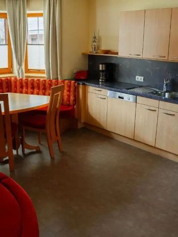 Gemütliche Ferienwohnungsküche mit Esstisch und Sitzbank