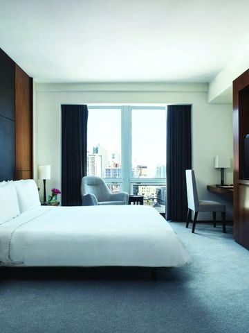 Geräumiges Schlafzimmer mit großem Fenster und Stadtblick