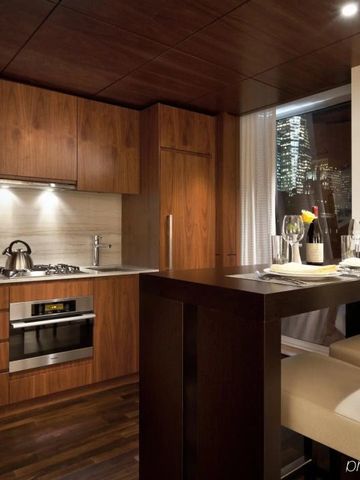 Elegante Hotelküche mit dunkler Holzeinrichtung und stilvoller Beleuchtung.