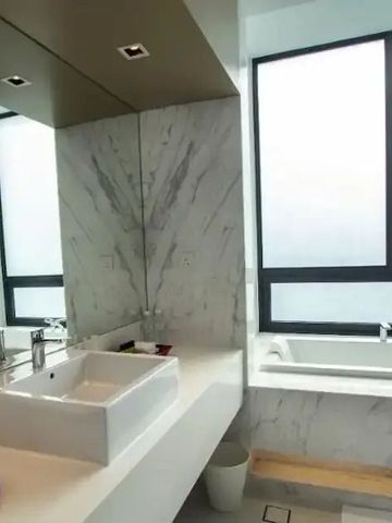 Luxuriöses Badezimmer mit Marmoroberflächen und großer Badewanne