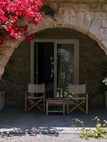 Natursteinbalkon mit Bougainvillea und Holzmöbeln