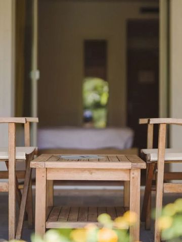 Holztisch und Stühle vor einer offenen Tür in ein Zimmer