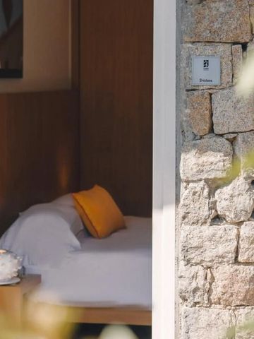 Helles Zimmer mit Steinmauer und gemütlichem Bett.