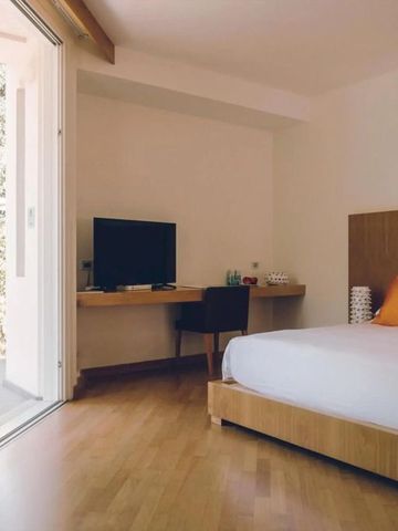 Modernes Zimmer mit Schreibtisch und großen Glastüren zur Terrasse.