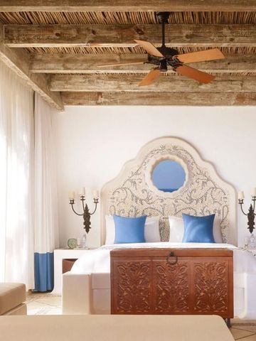 Zimmer mit kunstvoll geschnitztem Bettkopfteil und Deckenventilator