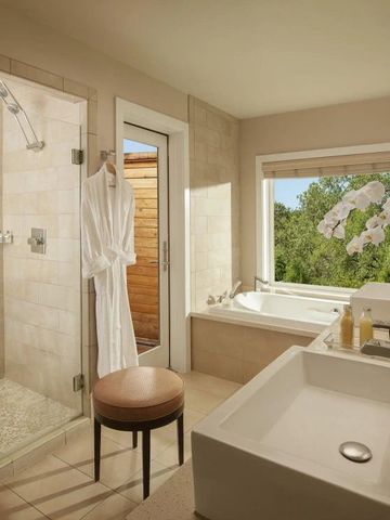 Luxuriöses Badezimmer mit freistehender Badewanne und großer Fensterfront