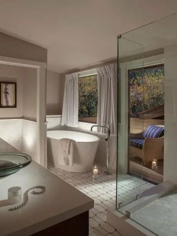 Helles Badezimmer mit freistehender Badewanne Blick auf Terrasse und Natur