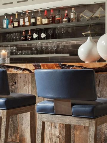 Elegante Hotelbar mit zwei blauen Hockern und großer Auswahl an Spirituosen