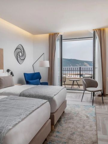 Geräumiges Hotelzimmer mit zwei Betten und Balkon mit Blick auf die Landschaft