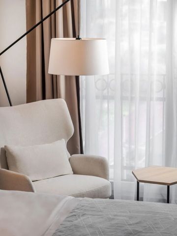 Eleganter Sitzbereich mit modernem Sessel und Lampe im Hotelzimmer