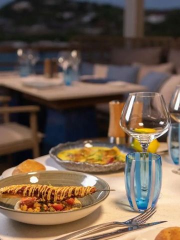 Eleganter Tisch auf Terrasse mit Blick auf das Meer und Gourmet-Essen im Vordergrund