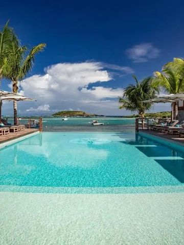 Infinity Pool des Le Barthélemy Hotel mit Blick auf das Meer und Palmen